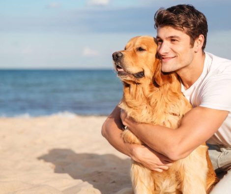 junger-mann-mit-golden-retriever-am-strand