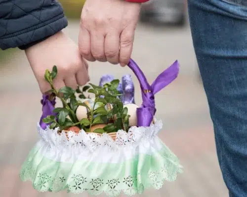 Zwei Hände tragen Osterkorb in der Mitte Ostern Geschenkideen