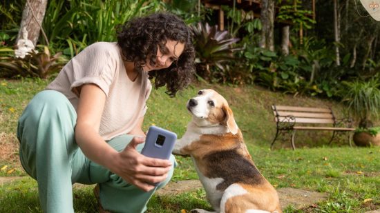 Frau macht mit Handy Foto von sich und Beagle