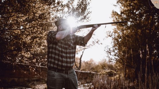 Jäger zielt mit Gewehr im Wald